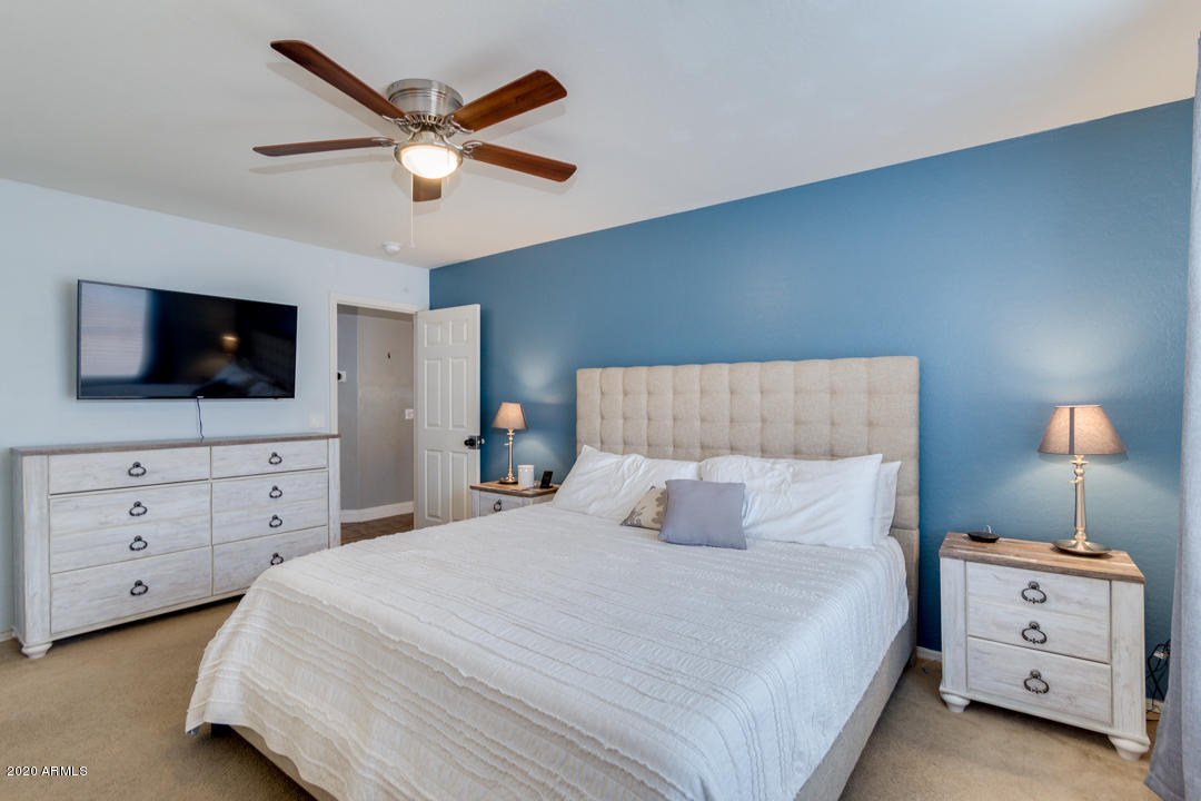 12714 West Calavar Road El Mirage, AZ 85335 - Photo 12 of 24 a bedroom with a large bed and a flat tv screen on dresser