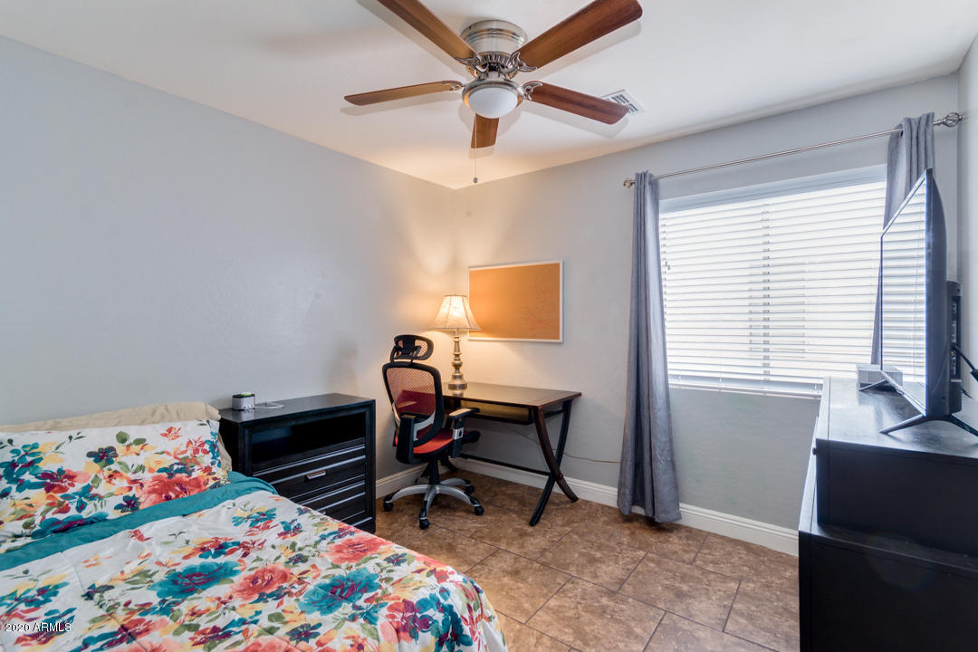 12714 West Calavar Road El Mirage, AZ 85335 - Photo 14 of 24 a bedroom with a bed and a window
