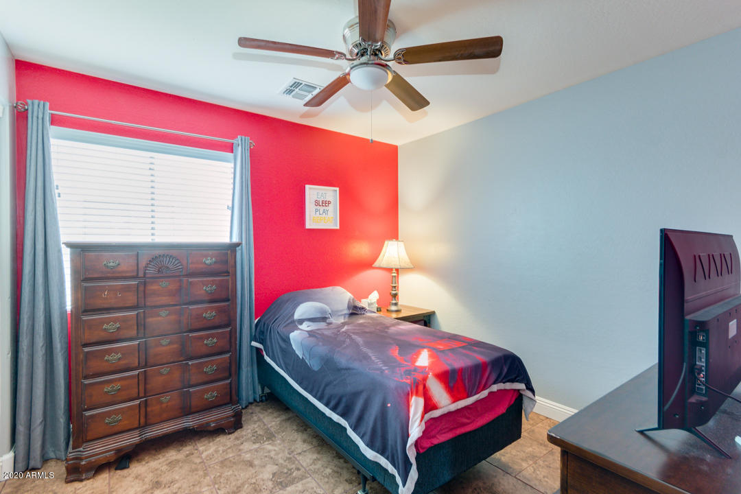 12714 West Calavar Road El Mirage, AZ 85335 - Photo 15 of 24 a bedroom with a bed and a dresser