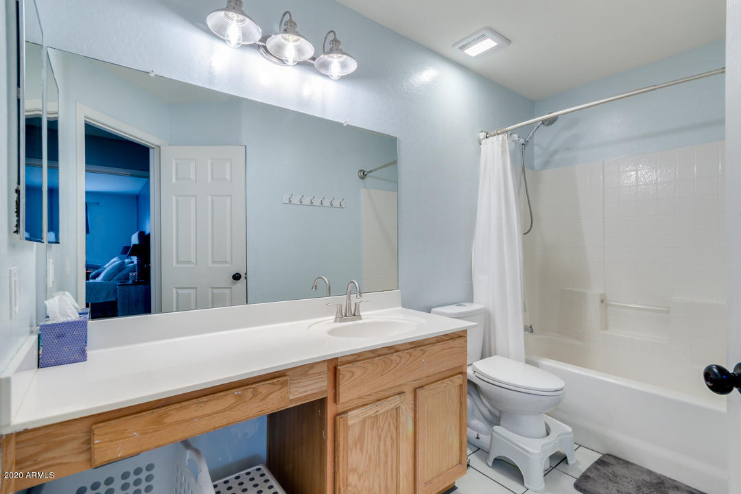 12714 West Calavar Road El Mirage, AZ 85335 - Photo 18 of 24 a bathroom with a sink a toilet a mirror and shower