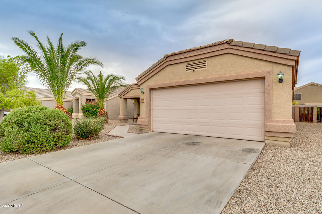 12714 West Calavar Road El Mirage, AZ 85335 - Photo 3 of 24 a view of a house with a small yard and plants