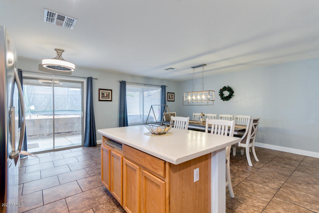 12714 West Calavar Road El Mirage, AZ 85335 - Photo 7 of 24 a view of a kitchen area with furniture and a window