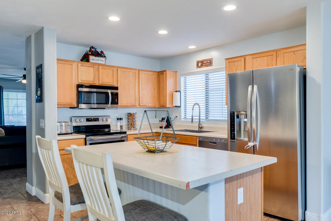 12714 West Calavar Road El Mirage, AZ 85335 - Photo 8 of 24 a kitchen with stainless steel appliances a refrigerator sink and microwave
