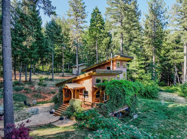 a view of a house with potted plants and a table and chairs