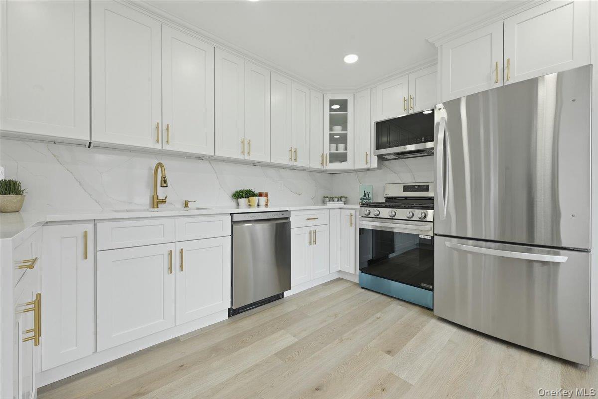 84 North Fordham Road Hicksville, NY 11801 - Photo 7 of 28 a kitchen with cabinets stainless steel appliances and wooden floor