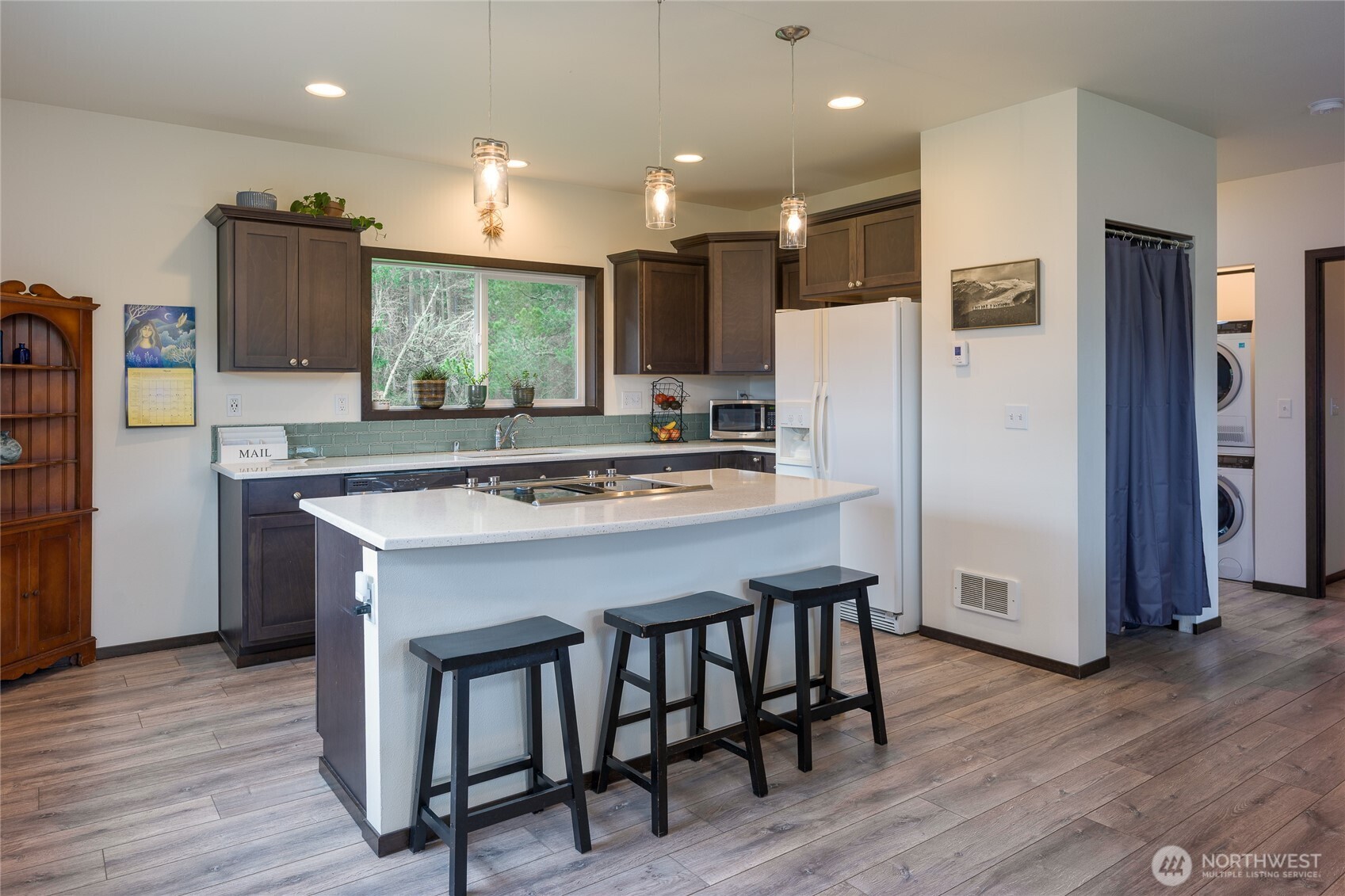 110 Clay Hill Road Lopez Island, WA 98261 - Photo 24 of 35 a kitchen with stainless steel appliances granite countertop a table chairs refrigerator a sink and a microwave