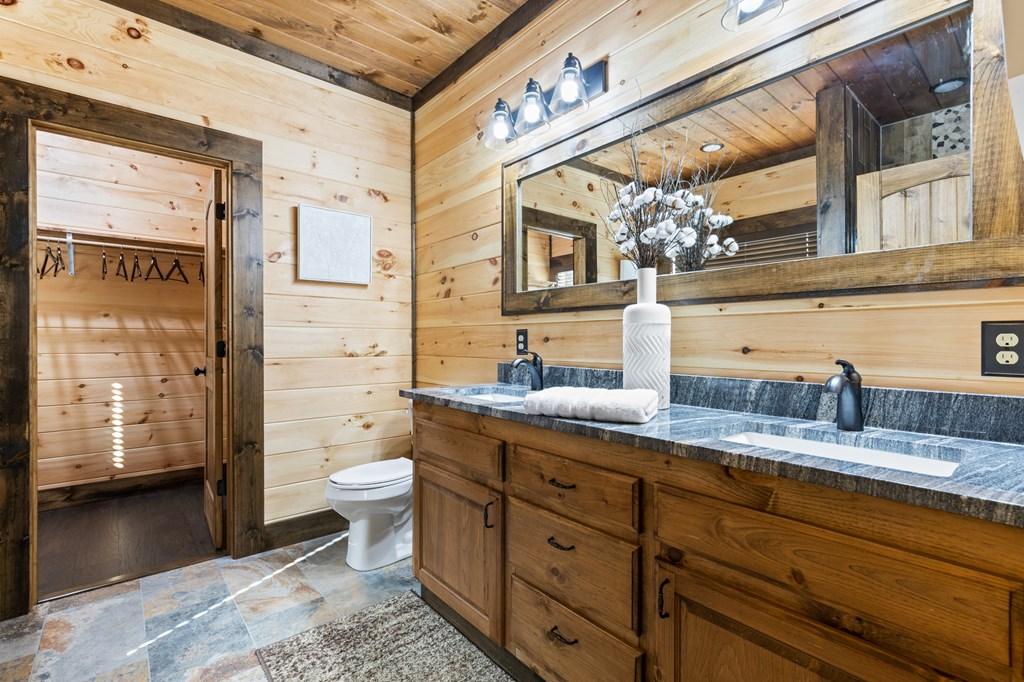 245 East Shalom Court Blue Ridge, GA 30513 - Photo 59 of 78 a bathroom with a granite countertop sink mirror vanity and toilet