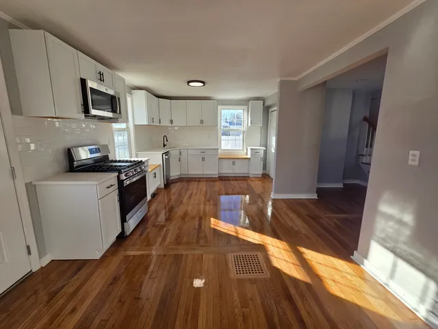 a kitchen with wooden floors and stainless steel appliances