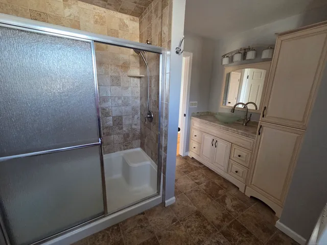 a bathroom with a granite countertop sink a mirror and a bathtub
