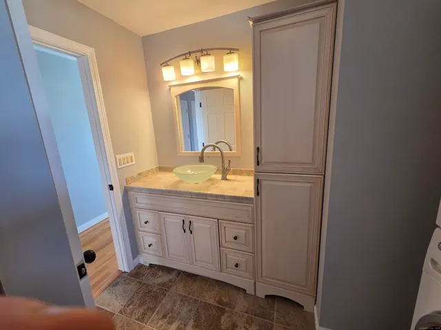 a bathroom with a granite countertop sink and a mirror