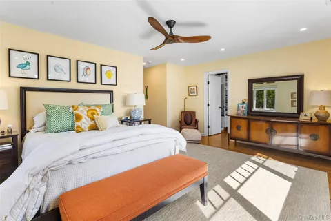 a bedroom with a bed a dresser and paintings on the wall