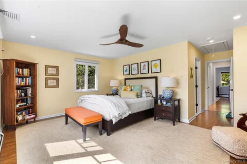 a bedroom with a bed a dresser and a book shelf