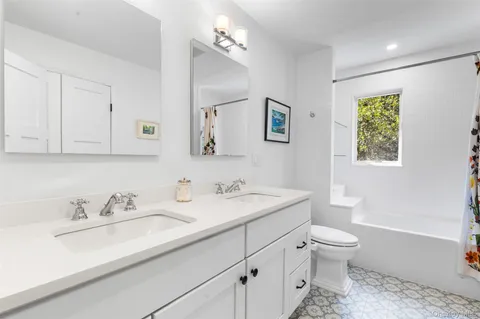 a bathroom with a sink toilet and a mirror