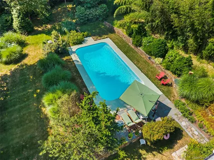 an aerial view of a house with a yard swimming pool and outdoor seating
