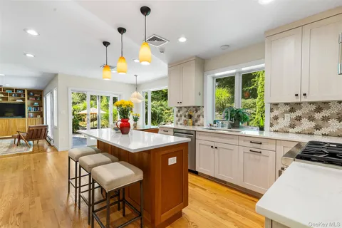 a kitchen with stainless steel appliances granite countertop a table and chairs in it