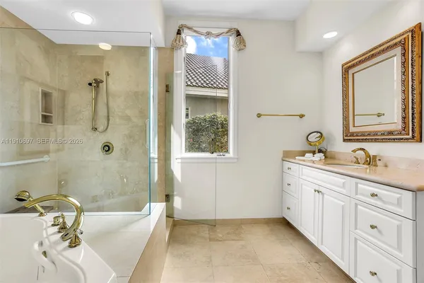 a bathroom with a tub sink and mirror