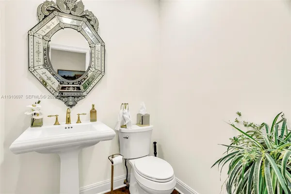 a bathroom with a toilet a sink and mirror