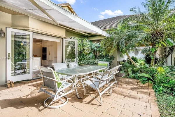 a view of a patio with table and chairs and potted plants