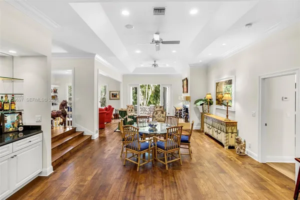 a view of a dining room and livingroom with furniture wooden floor a chandelier