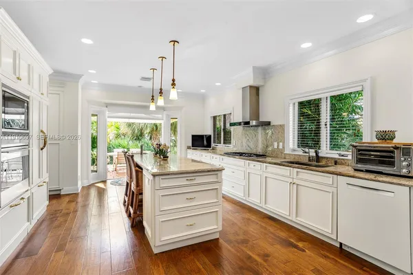 a large kitchen with granite countertop a large window and stainless steel appliances