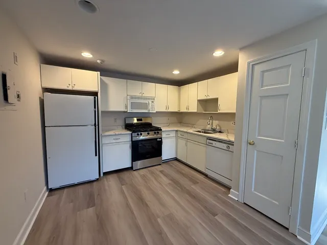 a kitchen with a refrigerator a sink and a stove top oven