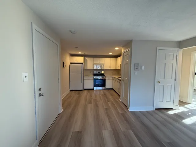 a view of a kitchen with a sink and refrigerator