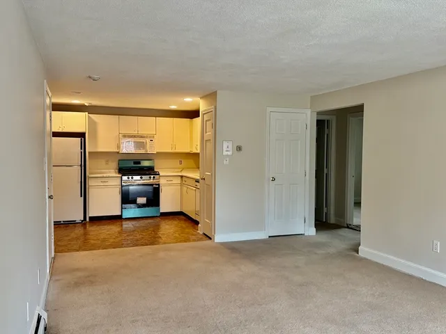a view of kitchen with stove and refrigerator