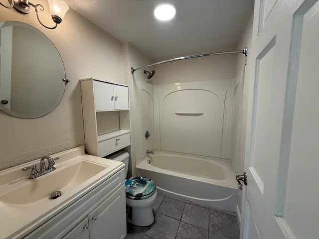 a bathroom with a tub a sink and mirror