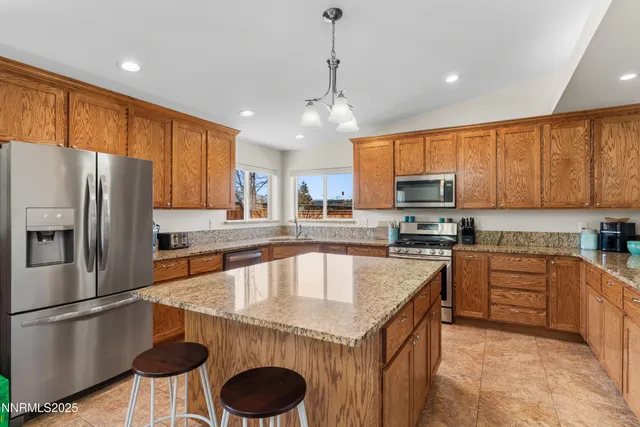 a kitchen with stainless steel appliances granite countertop a sink refrigerator stove and microwave