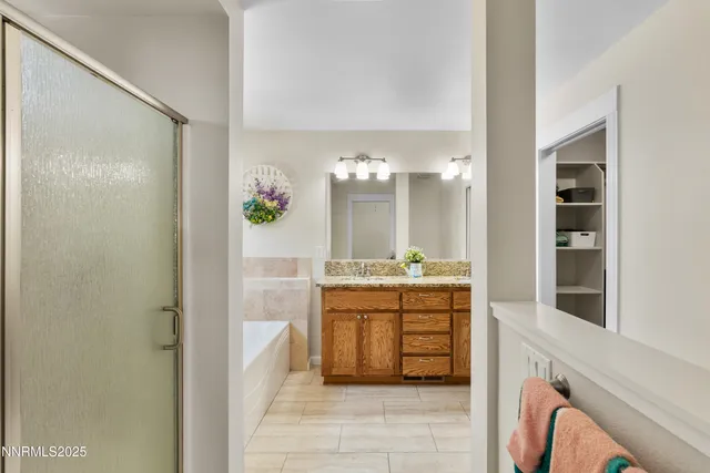 a bathroom with a granite countertop sink a mirror and a shower