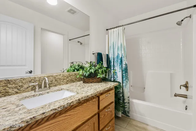 a bathroom with a granite countertop tub sink and mirror