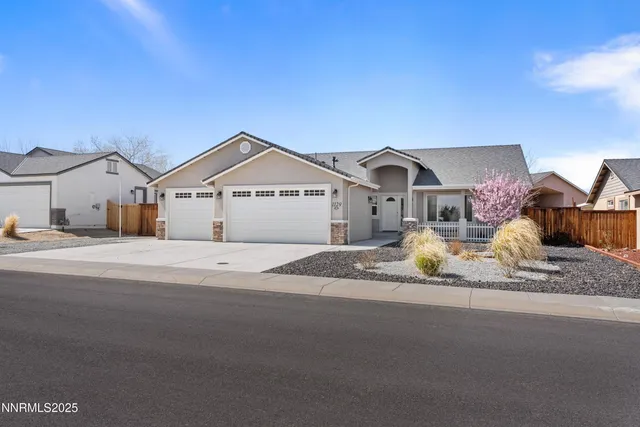 a front view of a house with a dirt yard and a car parked side of it