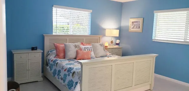 a bed sitting in a bedroom next to a window