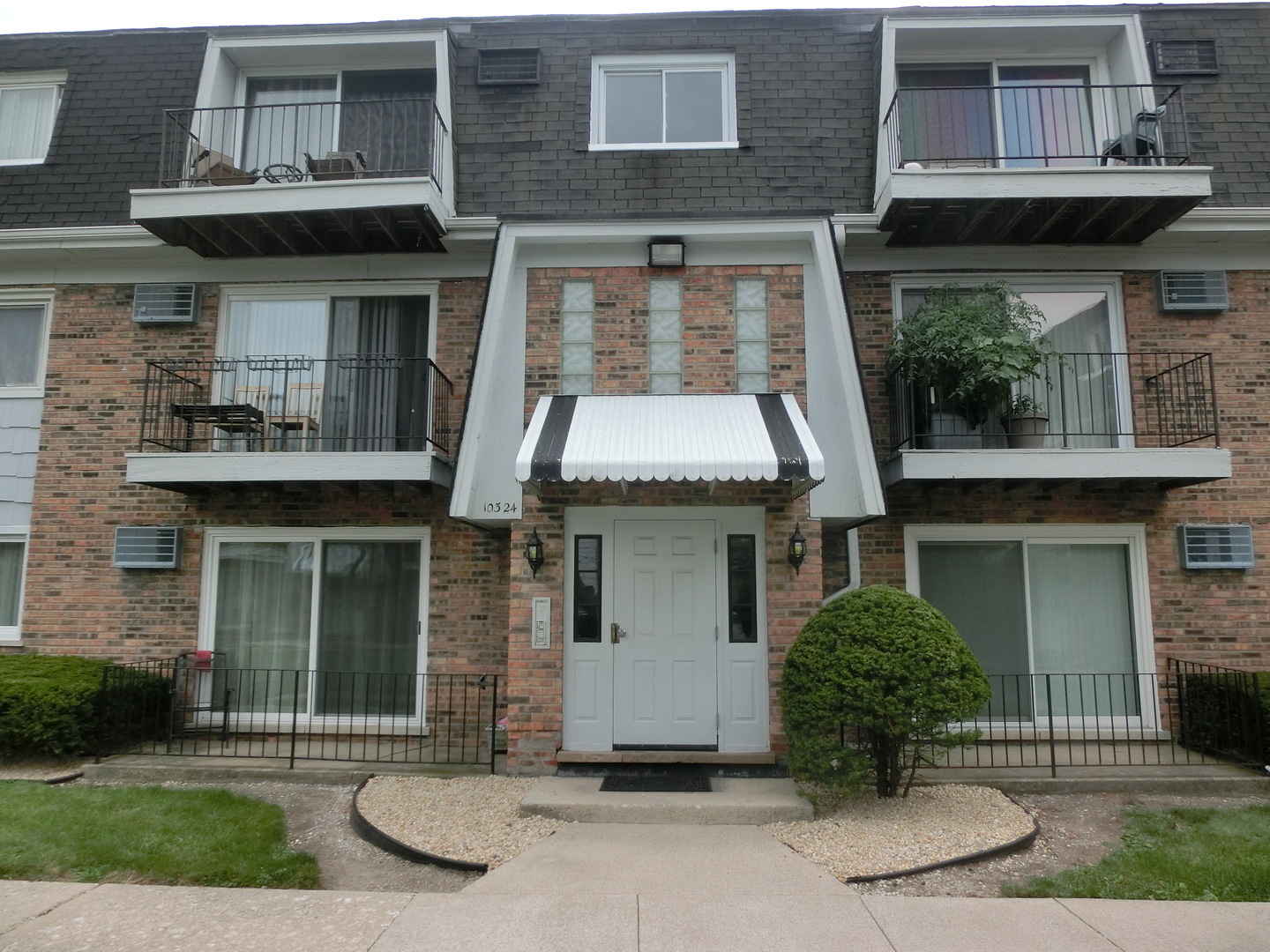 10324 South Ridgeland Avenue, Unit 105 Chicago Ridge, IL 60415 - Photo 16 of 16 a front view of a house with a garden and plants