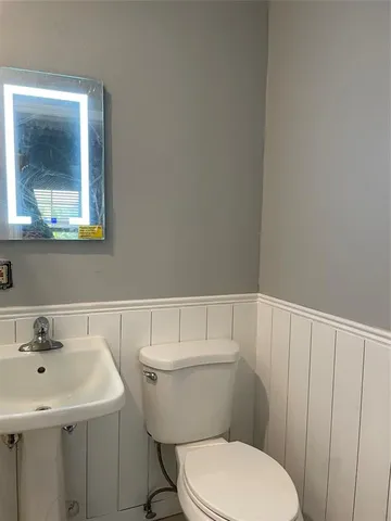 a bathroom with a sink a toilet and mirror