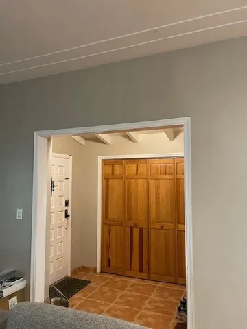 a view of a hallway with wooden floor and a bathroom
