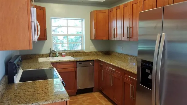 a kitchen with stainless steel appliances granite countertop a sink stove and refrigerator