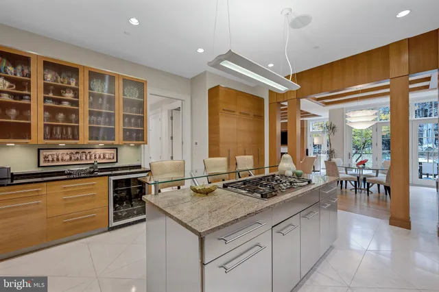 a kitchen with stainless steel appliances granite countertop table chairs sink and cabinets