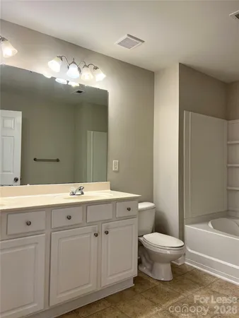 a spacious bathroom with a toilet sink and mirror