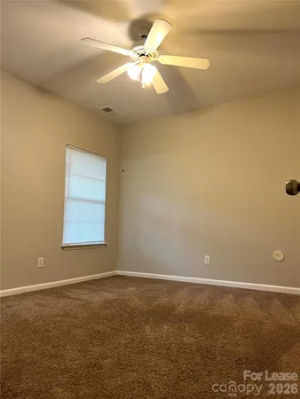 an empty room with a fan and a window