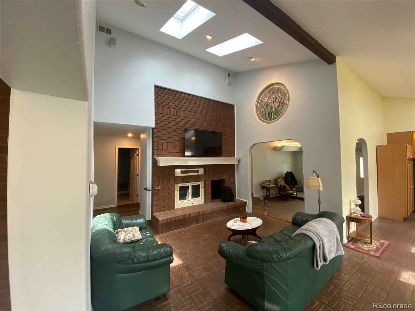 7079 Estes Drive Arvada, CO 80004 - Photo 19 of 50 a living room with furniture a mirror and a fireplace