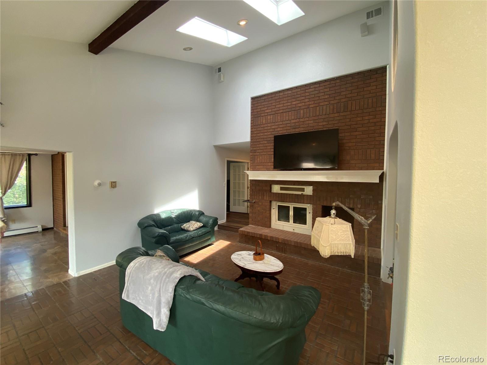 7079 Estes Drive Arvada, CO 80004 - Photo 20 of 50 a living room with furniture and a fireplace