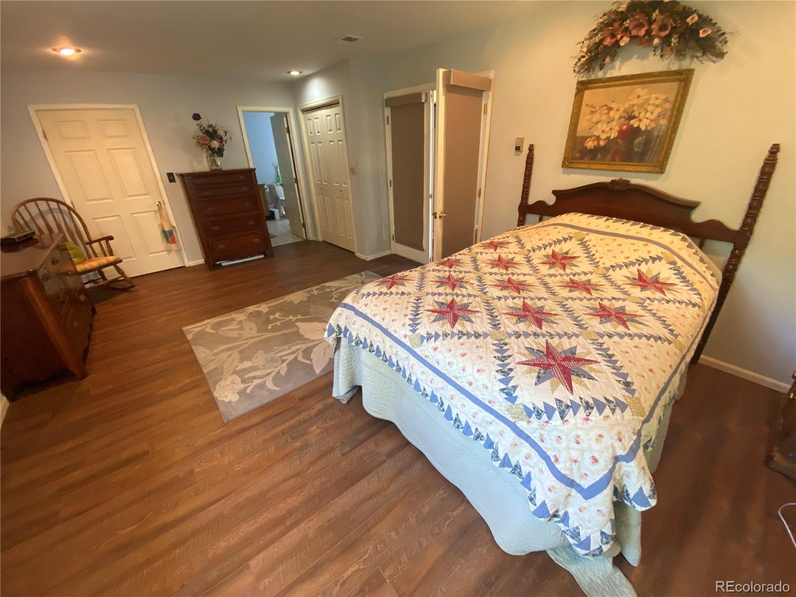 7079 Estes Drive Arvada, CO 80004 - Photo 21 of 50 a living room with a bed furniture and a wooden floor