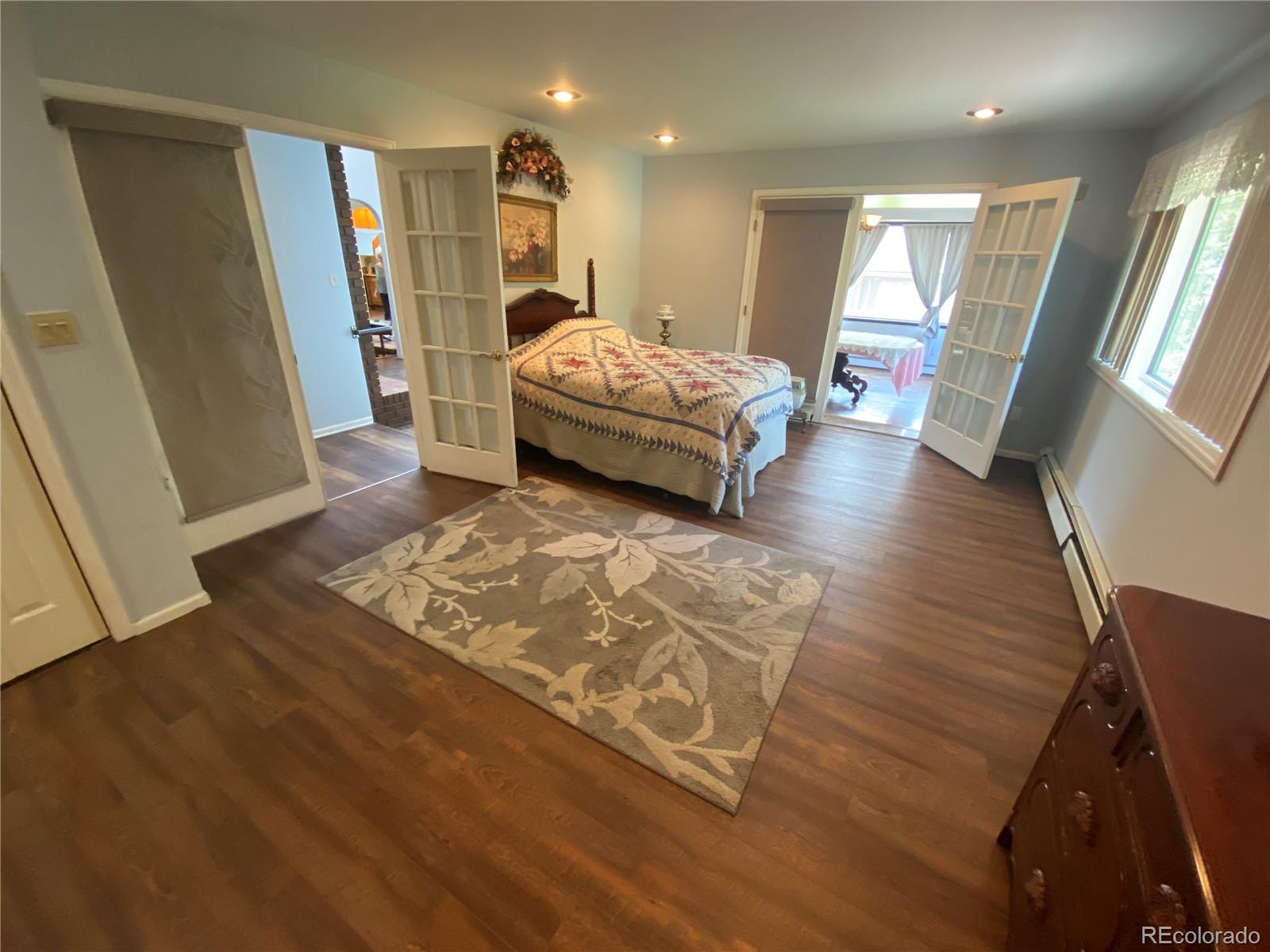 7079 Estes Drive Arvada, CO 80004 - Photo 22 of 50 a spacious bedroom with a bed and wooden floor