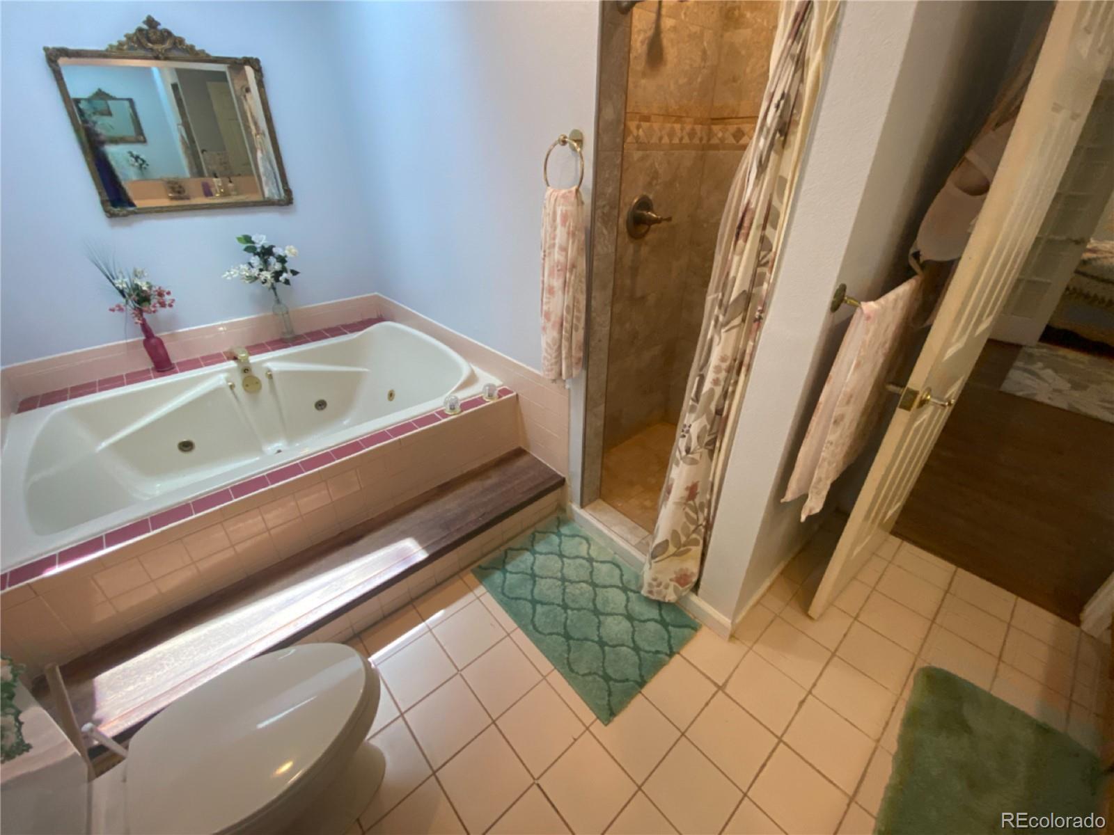 7079 Estes Drive Arvada, CO 80004 - Photo 26 of 50 a bathroom with a bathtub and a shower