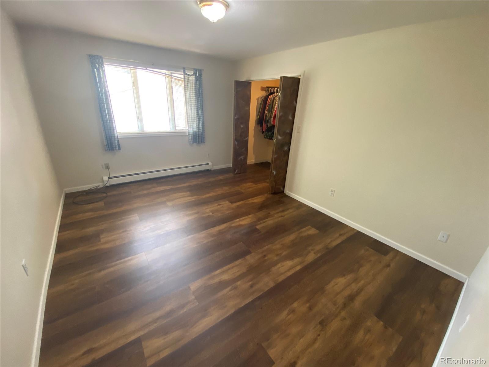 7079 Estes Drive Arvada, CO 80004 - Photo 27 of 50 an empty room with wooden floor and windows