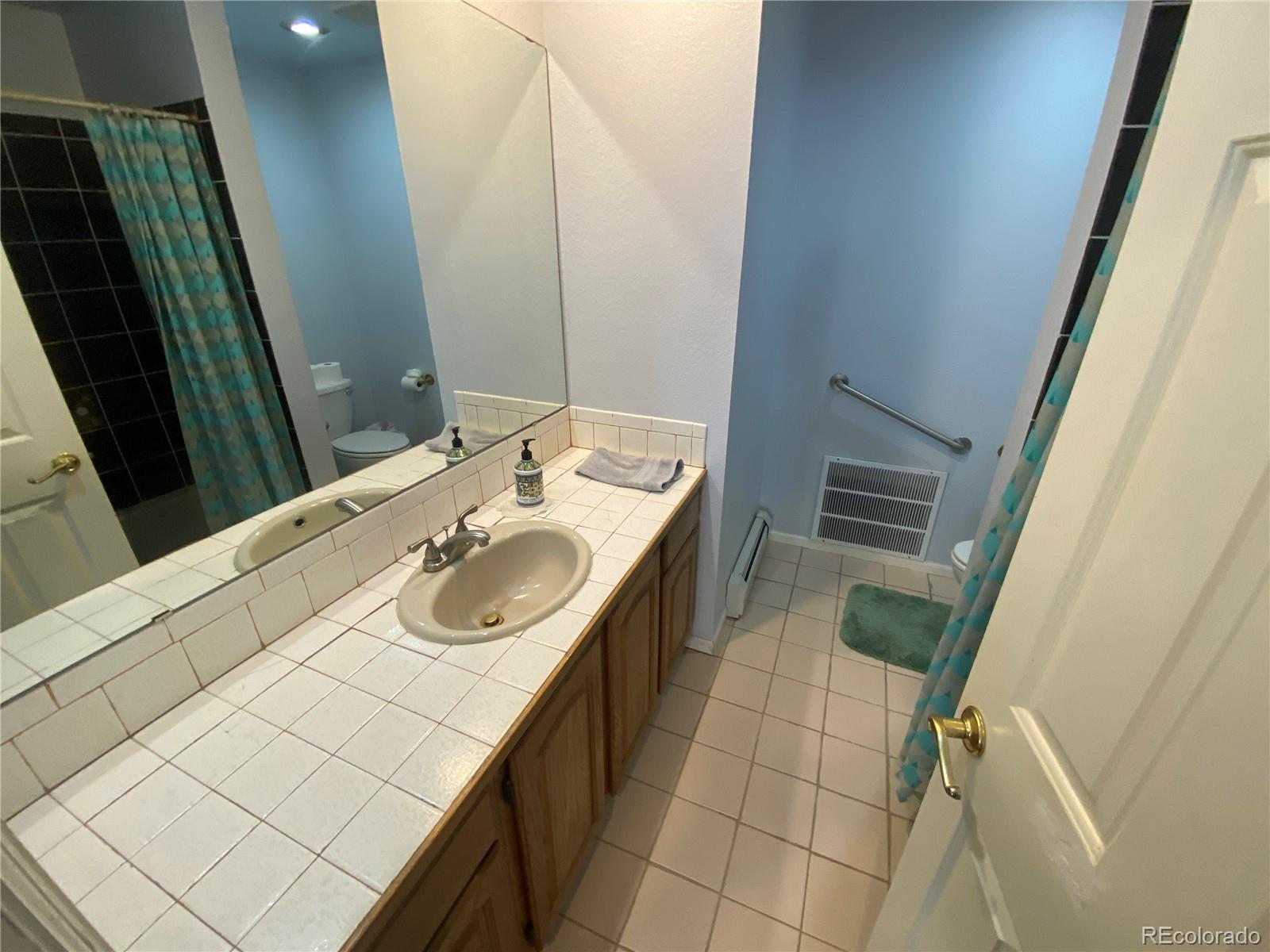 7079 Estes Drive Arvada, CO 80004 - Photo 28 of 50 a bathroom with a sink a toilet and a mirror