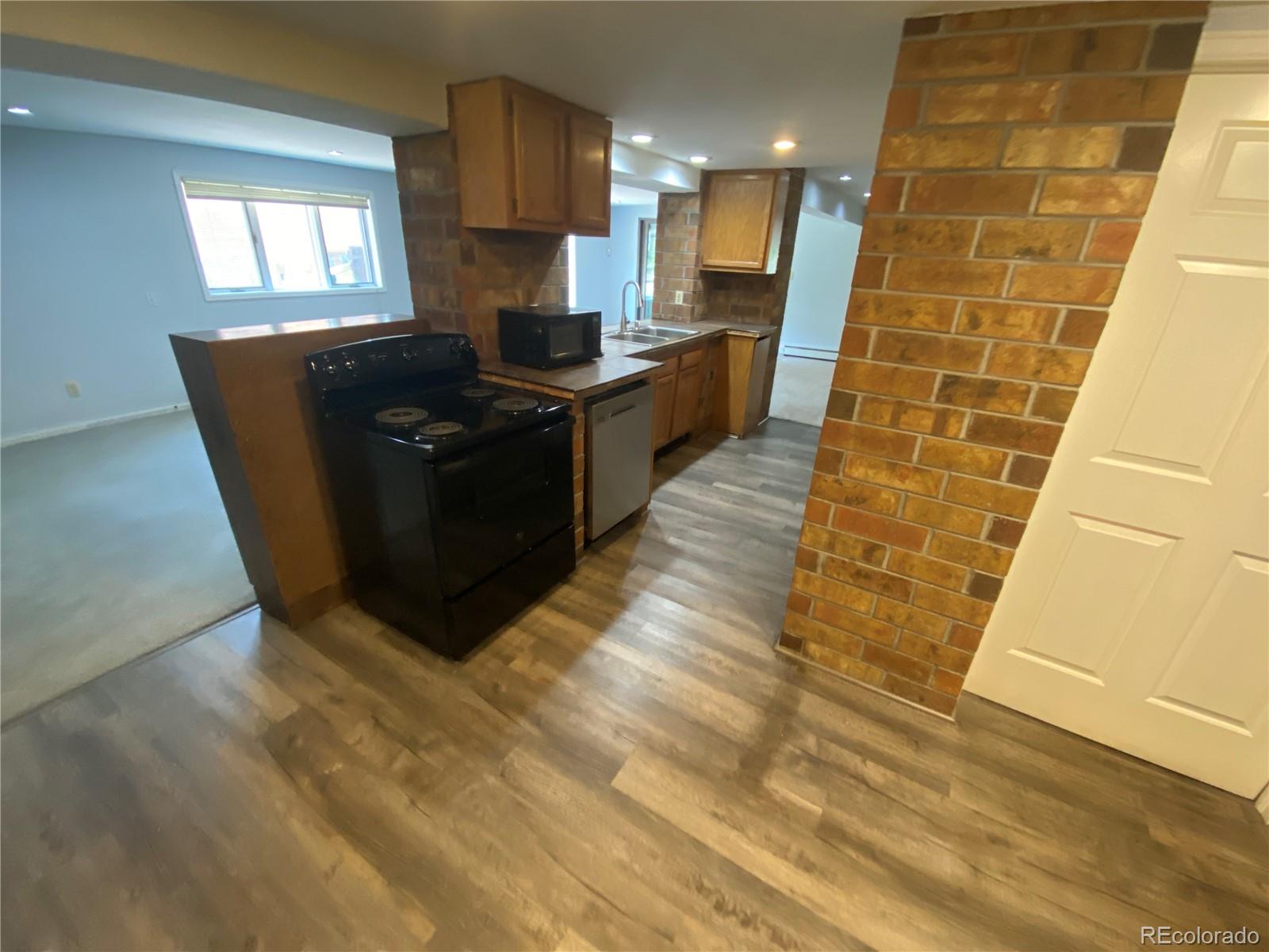 7079 Estes Drive Arvada, CO 80004 - Photo 33 of 50 a kitchen with granite countertop a sink and a counter top space