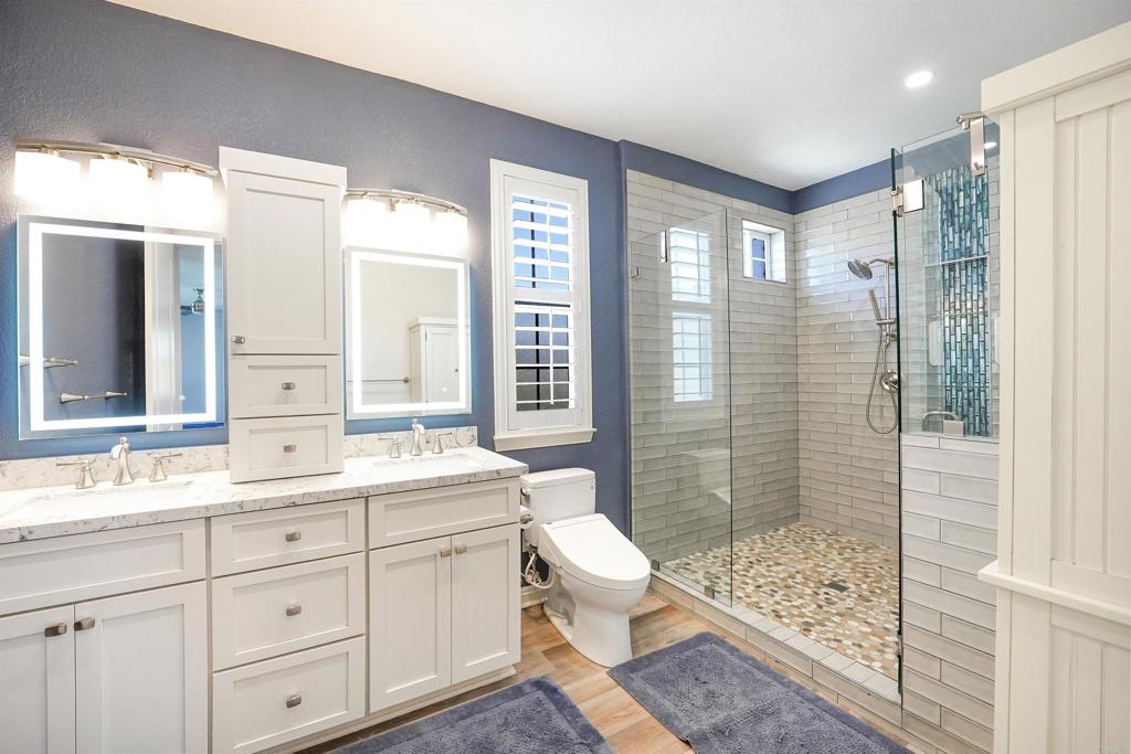 22963 Stokes Road Ramona, CA 92065 - Photo 36 of 57 a bathroom with a double vanity sink toilet and shower