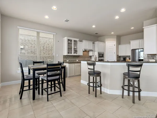 a kitchen with kitchen island a dining table and chairs
